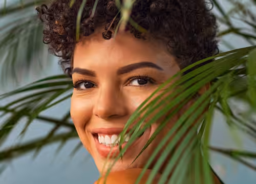 Happy woman next to palms