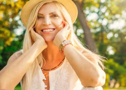Woman standing outside, wearing a sun hat