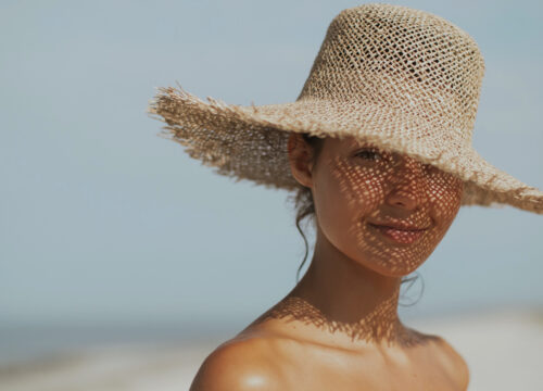 Photo of a woman wearing a sun hat at the beach